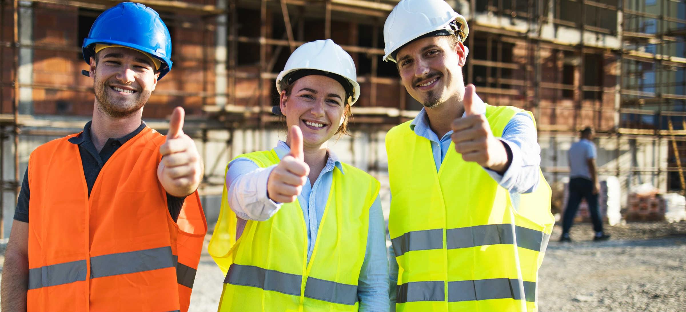 3 ouvriers devant un chantier de construction