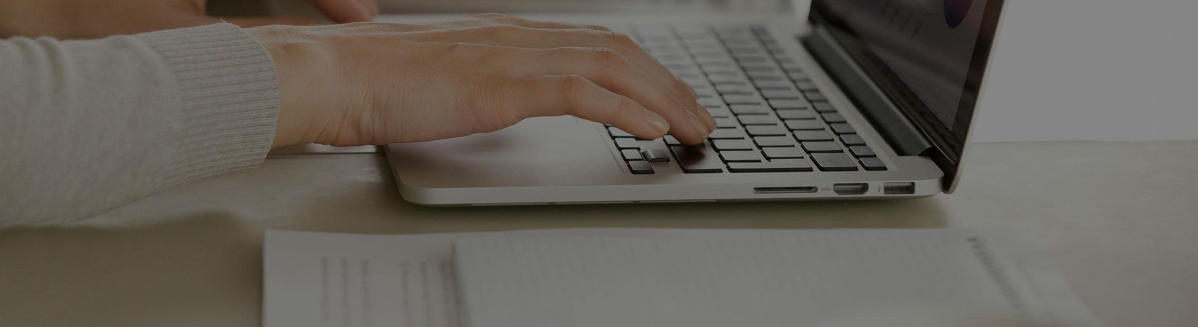 Une femme tape sur son clavier d'ordinateur